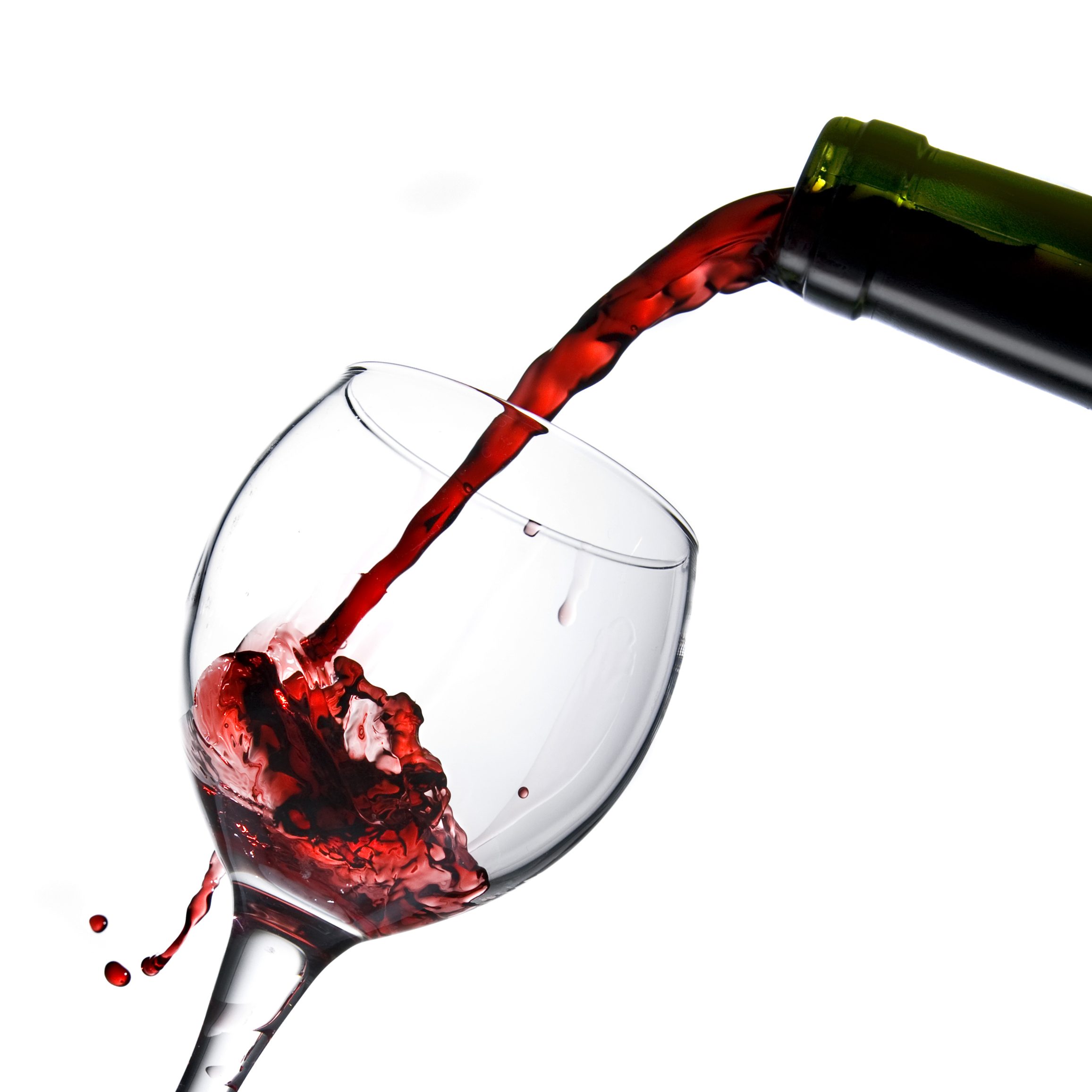 Pouring red wine in glass goblet isolated on white